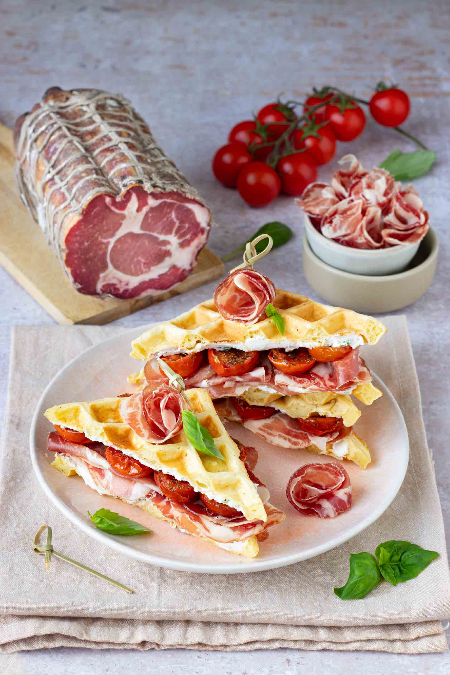 Sandwich di waffles salati con crema di ricotta al basilico, pomodorini confit e Coppa di Parma IGP